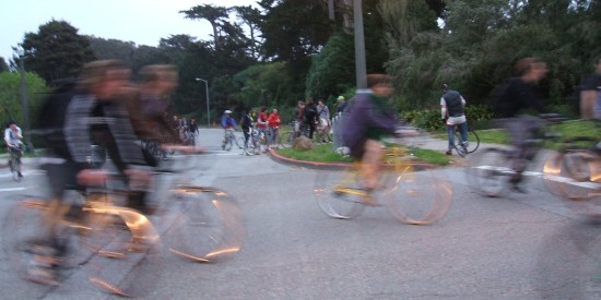 Critical Mass: sunset light glints on bicycle rims.